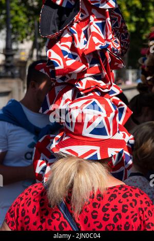 Westminster, London, Großbritannien. 8. August 2022. Das heiße Wetter hat sich in der Stadt fortgesetzt. Ein Weibchen probiert einen Union Jack Sonnenhut aus der Auswahl der Hüte Stockfoto