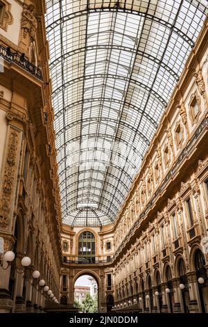 Mailand, Italien - 25. Juni 2022: Vertikales Foto der Gallerie Vittorio Emanuele II. Schöne Aussicht auf die älteste Shopping Gallery in der Lombardei. Stockfoto