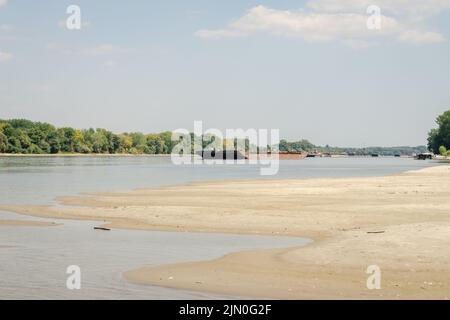 Blick auf die Donau. Ankerte Tanker auf dem gegenüberliegenden Ufer der Donau in der Nähe von Petrovaradin, Novi Sad, Serbien. Stockfoto