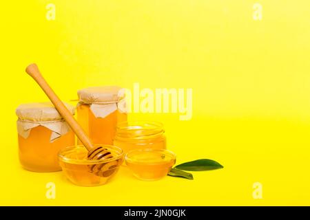 Honig im Glas mit Blättern und Honigtaube auf farbigem Hintergrund Draufsicht mit Text kopieren. Stockfoto