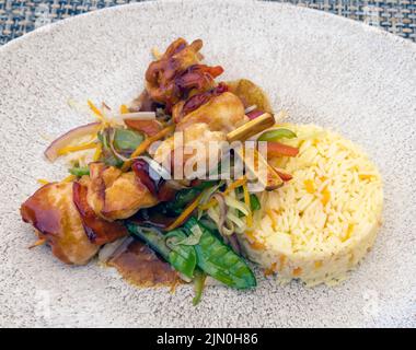 Hühnersaat mit Reis, Erdnusssauce und Gemüse. Stockfoto