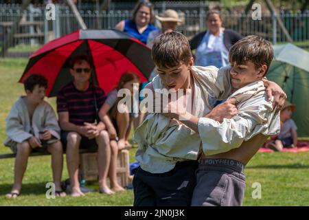 Zwei junge Brüder im Teenageralter treten beim Grand Cornish Wrestling Tournament auf dem malerischen Dorfgrün von St. Mawgan in Pydar in Cornwall in an Stockfoto