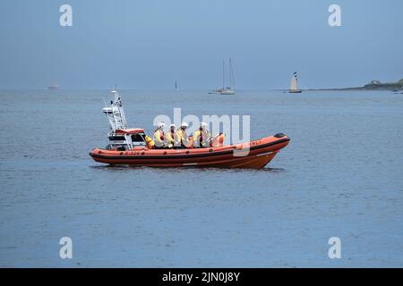 Das RNLI Atlantic 85 Rettungsboot Julie Poole B-926 und Crew auf See während des jährlichen Military Day Events im Trebah Garden in Cornwall in Großbritannien. Stockfoto