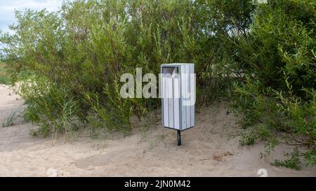 Ein weißer Müllcontainer am Ostseestrand. Lettland Stockfoto