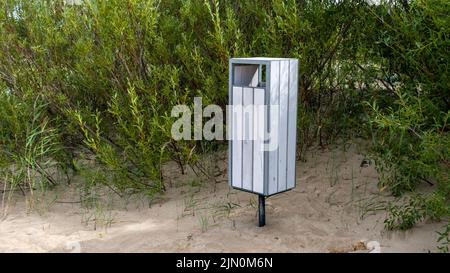Ein weißer Müllcontainer am Ostseestrand. Lettland. Stockfoto