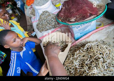 Kigali, Ruanda. 14.. Juli 2022. Ein Händler verpackt getrockneten Fisch mit einer Papiertüte auf dem Kimironko-Markt in Kigali, Ruanda, 14. Juli 2022. UM MIT "Feature: Ruanda macht Fortschritte beim Plastikverbot" zu GEHEN.Quelle: Cyril Ndegeya/Xinhua/Alamy Live News Stockfoto