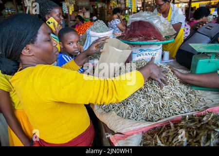 Kigali, Ruanda. 14.. Juli 2022. Ein Händler verpackt getrockneten Fisch mit einer Papiertüte auf dem Kimironko-Markt in Kigali, Ruanda, 14. Juli 2022. UM MIT "Feature: Ruanda macht Fortschritte beim Plastikverbot" zu GEHEN.Quelle: Cyril Ndegeya/Xinhua/Alamy Live News Stockfoto