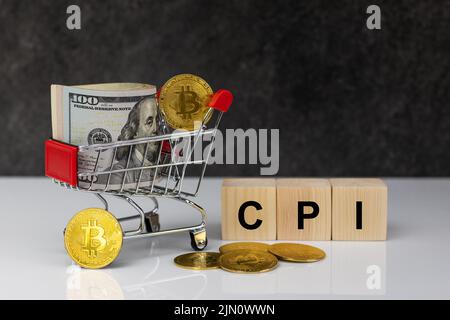 Bitcoin und Dollarrolle im Warenkorb oder Korb mit Holzblöcken mit Wort cpi auf dunkelgrauem Hintergrund. Kaufen oder verkaufen. Das Konzept des Impa Stockfoto