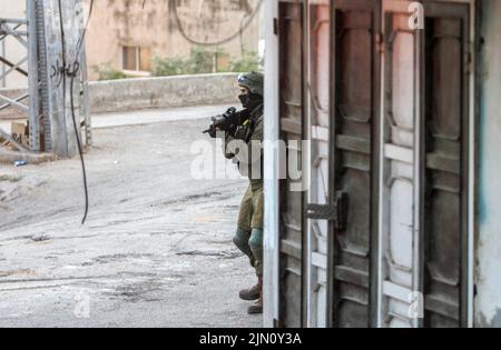 Jenin, Palästina. 02. August 2022. Ein israelischer Soldat nimmt seine Position während des Abrisses zweier palästinensischer Häuser im Dorf Rummana in der Nähe von Jenin im besetzten Westjordanland ein. Die israelischen Streitkräfte zerstörten die Häuser der in israelischen Gefängnissen inhaftierten Palästinenser, Sobhi Sbeihat, 29, und Hassan Al-Rifai, 19, Die verdächtigt wurden, drei Israelis in der israelischen Stadt Erad getötet zu haben. Kredit: SOPA Images Limited/Alamy Live Nachrichten Stockfoto