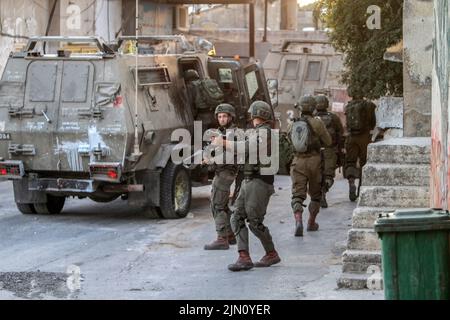 Jenin, Palästina. 02. August 2022. Israelische Soldaten nehmen ihre Positionen während des Abrisses von zwei palästinensischen Häusern im Dorf Rummana in der Nähe von Jenin im besetzten Westjordanland ein. Die israelischen Streitkräfte zerstörten die Häuser der in israelischen Gefängnissen inhaftierten Palästinenser, Sobhi Sbeihat, 29, und Hassan Al-Rifai, 19, Die verdächtigt wurden, drei Israelis in der israelischen Stadt Erad getötet zu haben. (Foto von Nasser Ishtayeh/SOPA Images/Sipa USA) Quelle: SIPA USA/Alamy Live News Stockfoto