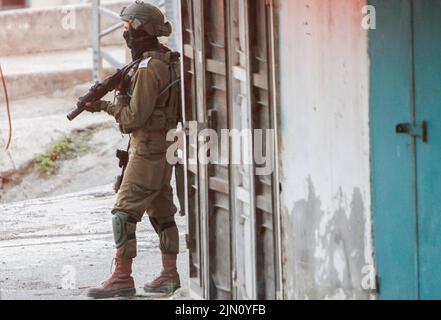 Jenin, Palästina. 02. August 2022. Ein israelischer Soldat nimmt seine Position während des Abrisses zweier palästinensischer Häuser im Dorf Rummana in der Nähe von Jenin im besetzten Westjordanland ein. Die israelischen Streitkräfte zerstörten die Häuser der in israelischen Gefängnissen inhaftierten Palästinenser, Sobhi Sbeihat, 29, und Hassan Al-Rifai, 19, Die verdächtigt wurden, drei Israelis in der israelischen Stadt Erad getötet zu haben. (Foto von Nasser Ishtayeh/SOPA Images/Sipa USA) Quelle: SIPA USA/Alamy Live News Stockfoto