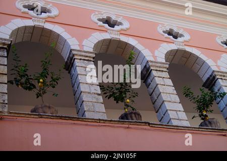 Ein herrliches rosafarbenes mediterranes Haus mit achter Galerie und Zitronenbäumen in Körben in der Stadt Limone sul Garda (Italien, Lombardei) Stockfoto