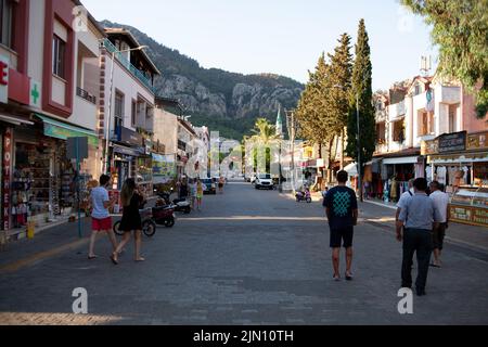 Touristen gehen an einer Cafeteria und einem Souvenirladen in einem kleinen Ferienort vorbei. Street Food und Souvenirläden auf der Hauptstraße. Turunc, Türkei - 7. September 2 Stockfoto