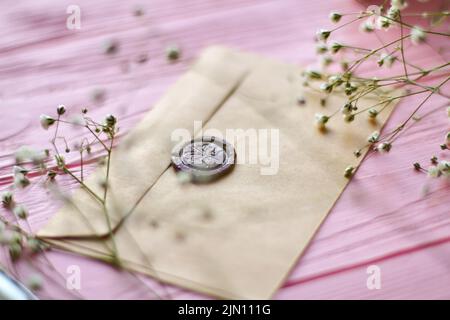 Nahaufnahme des Umschlags mit braunen Wachsdichtungen. Hintergrund aus rosa Holz. Stockfoto