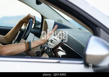 Weibliche Hand prüfen Klimaanlage Panel im Auto. Frau, die die Hand an der Klimaanlage hält Stockfoto