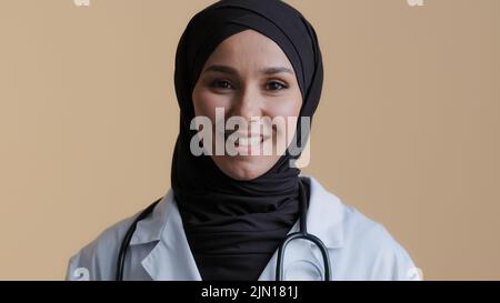 Junge muslimische professionelle Frau Ärztin in Hijab weiß medizinische Uniform Beratung Remote-Patient Blick auf Kamera Webcam virtuelle Stockfoto