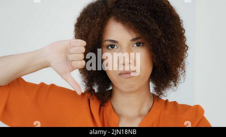 Nahaufnahme African American Millennial traurig frustriert enttäuschte Frau mit lockigem Haar Mädchen suchen Kamera zeigt Abneigung Daumen nach unten Uneinigkeit Stockfoto