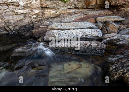 10. Juli 2022. 7:35pm Uhr. Felsen bei Flut auf Barnes Island. Casco Bay. Maine. Gezeitenserie. Zweiter von zwei. Stockfoto