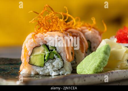 Sushi-Set mit verschiedenen Produkten auf einem Steinteller. Verwischen Sie den Hintergrund und den selektiven Fokus Stockfoto