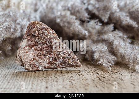 Alurgit ist eine Vielzahl von Moskauer Mineralsteinen. Nahaufnahme der rauhen Kristallbildung auf dem Felsen. Kristallheilung Stockfoto