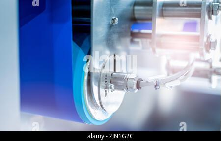 Selektiver Fokus auf Trommelmotor mit blauem Förderband. Elektromotor in der Lebensmittelfabrik. Rollenmotor aus Edelstahl. Lebensmitteltechnische Ausrüstung. Stockfoto