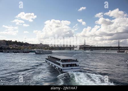 Blick auf die Ausflugsboote am Goldenen Horn, Teil des Bosporus und die Halic-Brücke in Istanbul. Es ist ein unsanger Sommertag. Stockfoto