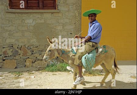 Heimischer reitet auf einem Esel, Sal Rei, Boavista, Kapverden, Afrika | Ältere Mann auf einem Esel, Sal Rei, Boavista, Kapverdische Inseln, Afrika Stockfoto
