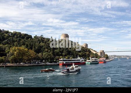 Blick auf Boote, die am Bosporus vorbeifahren, und die historische Festung Rumeli Hisari auf der europäischen Seite Istanbuls. Es ist ein sonniger Sommertag. Wunderschöner Reisender Stockfoto