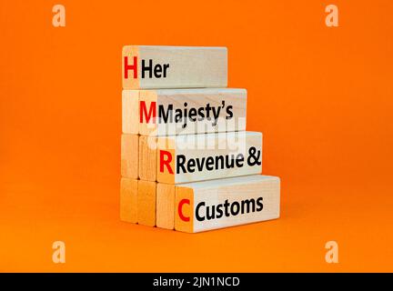 HMRC her majestys Einkommens- und Zollsymbol. Konzept Worte HMRC her majestys Einnahmen und Bräuche auf Blöcken auf schönen orangen Hintergrund. Geschäftlich H Stockfoto