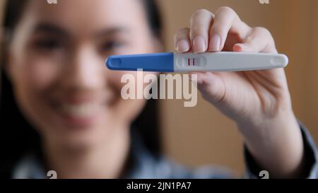 Portrait defokussiert asiatische Mädchen schwanger glücklich Frau schwanger Zukunft Mutter halten zeigt positive Schwangerschaftstest erwartet Baby neues Leben Säugling Stockfoto