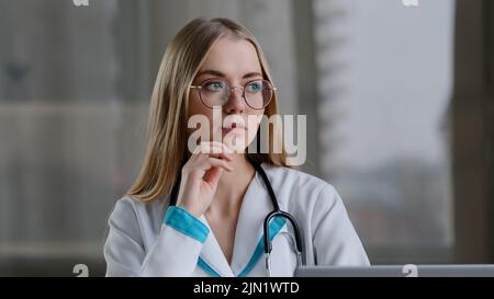 Fokussierte kaukasische weibliche nachdenkliche Krankenschwester intelligente Frau Praktiker Arzt denken an Problemdiagnose Termin Lösung trifft Entscheidung kommt mit Stockfoto