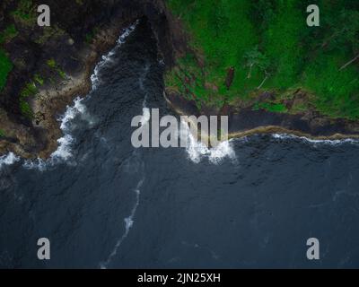 Luftaufnahme. Dunkelblaues Meer und grüne hügelige Küste. Ruhig. Wunderschöne Natur. Umweltschutz, Ökologie, Klimawandel, globale Erwärmung. Da ist ein Stockfoto