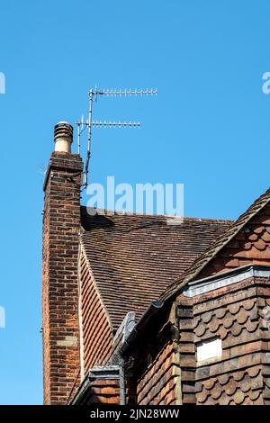 Dorking, Surrey Hills, London, Großbritannien, Juli 07 2022, Traditionelles Gebäude aus Ziegelstein und Fliesen, Außenarchitektur mit klassischem Kamin und TV-Antenne Stockfoto