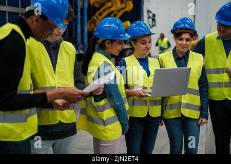 Gruppe von Ingenieuren, die Daten zu Robotermaschinen überprüfen Stockfoto
