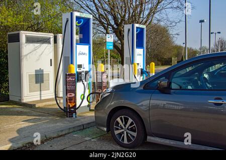 Harlow, Essex / England -März 23 2022: Nissan Leaf wird an einer BP Polar DC Ladestation in Harlow Essex, England, aufgeladen. Mit CHAdeMO-Stecker Stockfoto