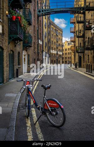 London, Großbritannien - Jun 10 2022: Santander Bike in Shad Thames, einer der ältesten Straßen Londons; Sustainable bike sharing System Wallpaper Stockfoto