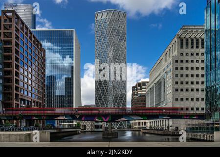 London, Großbritannien - Jun 10 2022: Die Docklands Light Railway-Bewegung verschwimmt am Canary Wharf mit dem Neufundland-Gebäude im Hintergrund Stockfoto