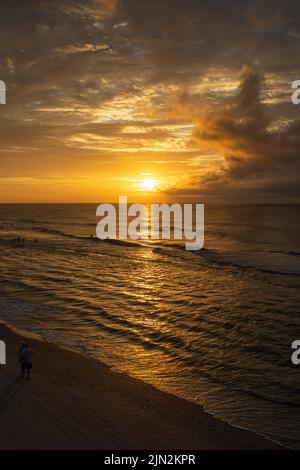 Die Sonne geht über dem Horizont an der Atlantikküste unter. Stockfoto