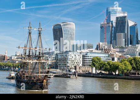 Alt und neu im Kontrast: Das (nachgebaute) Segelschiff Göteborg aus dem 18.. Jahrhundert nähert sich der Tower Bridge, die Besatzung im Takeling, die von Londoner Wolkenkratzern übersehen wird. Stockfoto