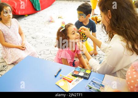 BAKU, ASERBAIDSCHAN- 13 MAY 2019 : Mädchen zeichnet kleine Mädchen Aqua Make-up. Gesichtsbemalung. Freizeit für Kinder. Stockfoto