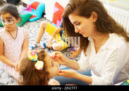 BAKU, ASERBAIDSCHAN- 13 MAY 2019 : Mädchen zeichnet kleine Mädchen Aqua Make-up. Gesichtsbemalung. Freizeit für Kinder. Stockfoto