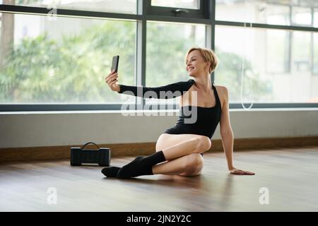 Glückliche Tänzerin beim Selfie im Studio Stockfoto