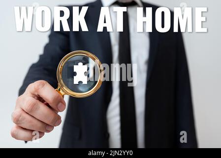 Schild mit der Anzeige „Arbeit zu Hause“. Konzeptfoto Freiberufler Job Arbeiten an Ihrem Haus bequeme Technologie Mann mit Vergrößerungsglas zu zeigen Stockfoto