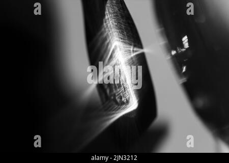 Glasflasche wirft einen schönen Schatten und ätzenden Effekt, wenn Licht durch ein Glas geht. Schwarzweiß-Foto. Abstrakter Hintergrund Stockfoto