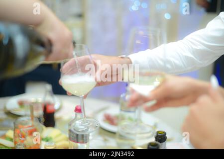 Familie verschiedener Altersgruppen Menschen fröhlich feiern drinnen mit Gläsern Weißwein, verkünden Toast Stockfoto