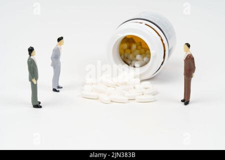 Miniatur Menschen Spielzeug Figur Fotografie. Ein alter Mann, der mit einem Stock oder einer Krücke in der Mitte von Medikamentenpillen läuft. Medizinisches Zugangskonzept. Bildfoto Stockfoto