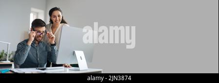 Zwei glückliche Kollegen, die gemeinsam an einem Startup-Projekt arbeiten, kopieren Speicherplatz Stockfoto
