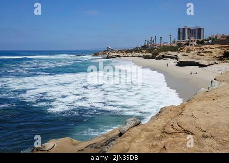 Kleine Küstenzufahrt, umgeben von malerischen Sandsteinfelsen, die den beliebten La Jolla Cove Beach in San Diego, Kalifornien, schützen Stockfoto