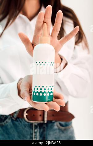 Ein Mädchen hält ein Haarpflegeprodukt in den Händen Stockfoto