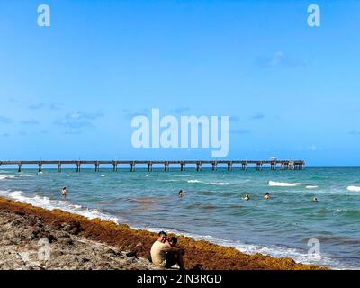 Dania Beach, FL - USA 27. Juli 2022 Landschaftsansicht des Dania Beach Ocean Park Pier und Schwimmer am Atlantischen Ozean im Süden Floridas. Stockfoto